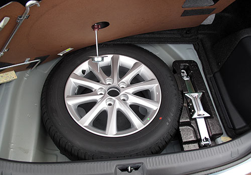 The Hybrid Camry comes with a full-size spare and included in the kit you'll find with the spare is a towing hook that has to be attached before the vehicle can be towed with a strap.